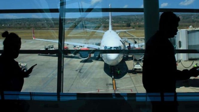 Calon penumpang di bandara berjalan menuju pesawat terbang. (Foto ilustrasi)