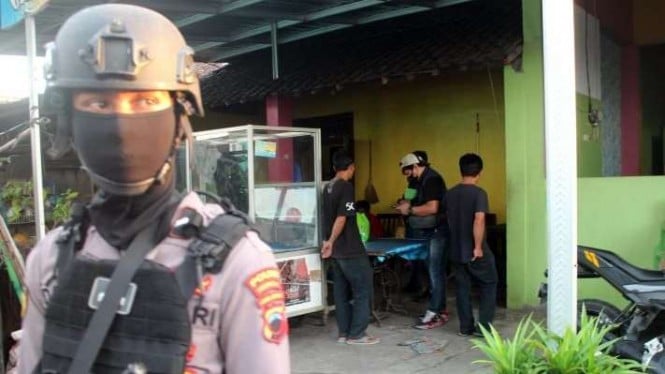 Seorang petugas kepolisian saat menjaga di depan rumah terduga terioris Dukuh Kluyon, Desa Waru, Kecamatan Baki, Kabupaten Sukoharjo, Jawa Tengah, Kamis petang, 1 Desember 2022.